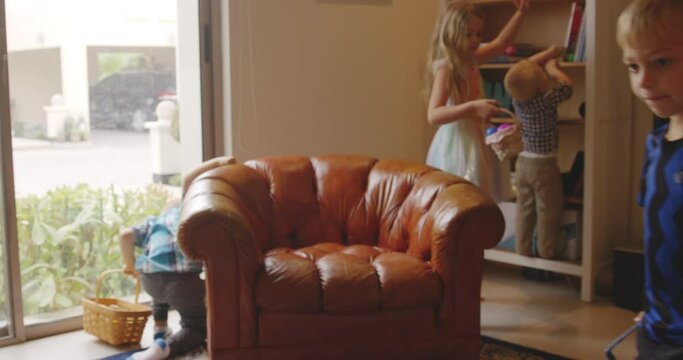 Three boys and one girl searching for the Easter eggs around the living room.