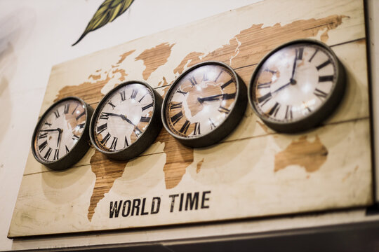 Four timezone wall clocks showing different time in the world with vintage design.