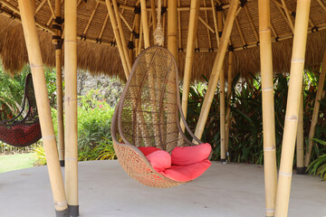 Rattan hanging chair on wooden bamboo eco house at terrace 