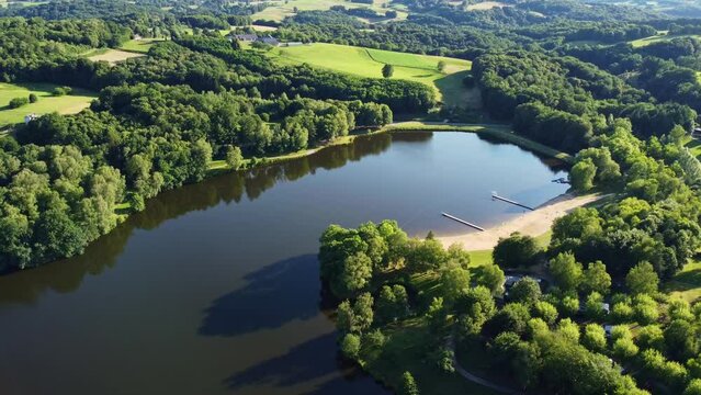 Etang de Pontcharal per&ccedil;u du ciel avec son magnifique reflet ensoleill&eacute;. Lac fran&ccedil;ais entour&eacute; de verdure comportant une petite plage.