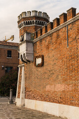 Naklejka premium Architectural detail of a red brick wall and watch tower of an old prison in Venice, Italy.