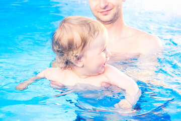 Baby girl with father in a pool. Little baby learn to swimm
