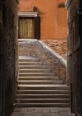 Fototapeta na wymiar View of bridge and street from an alley in Venice, Italy 