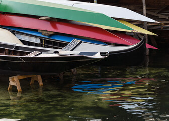 Fototapeta na wymiar closeup detail of colorful boats and black gondola at boatyard in Venice, Italy 