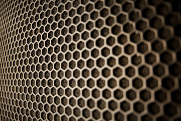 Abstract background is a black metal grid for the speaker close-up. Details audio equipment. Soft focus. Black iron speaker grid texture