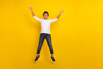 Fototapeta na wymiar Photo of charming attractive schoolkid dressed white shirt jumping high isolated yellow color background