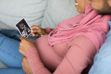 Preparing For Parenthood. Happy Black Pregnant Muslim Couple Looking At Baby Sonography