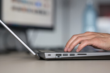 Closeup of a person's hand typing on a laptop