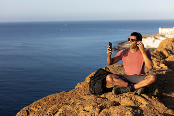 Fototapeta na wymiar Young man taking selfie photo on a road trip. Man making memories on the mountain