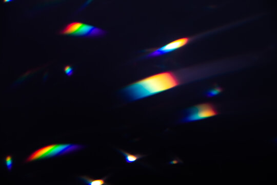 Blur colorful warm rainbow crystal light leaks on black background. Defocused abstract retro film analog effect for using over photos as overlay or screen filter