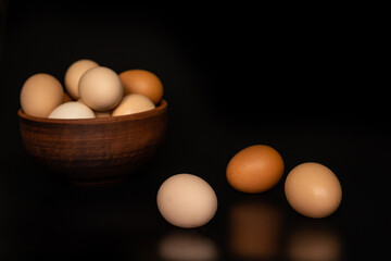 Eggs of different shades in a bowl  on a black background