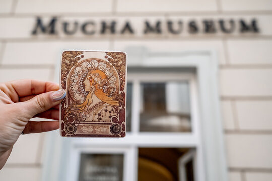 Prague, Czech Republic - July 2022. Alphonse Mucha Museum. Woman holding ticket with Zodiac calendar for La Plume. Gallery dedicated to renowned painter, illustrator, graphic artist.