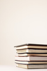 Vertical image of stack of books on beige surface