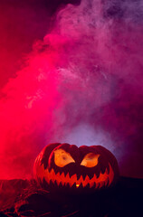 Fototapeta premium Composition of halloween carved pumpkin with smoke and red light on black background