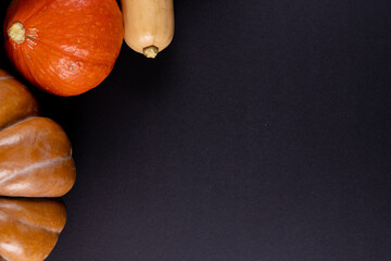 Composition of multiple orange pumpkins lying on black background