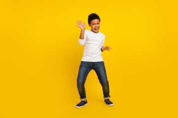 Fototapeta na wymiar Photo of charming funky schoolboy wear white shirt smiling dancing isolated yellow color background