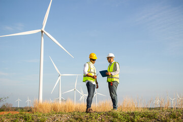engineer team working in wind turbine farm. Renewable energy with wind generator by alternative...