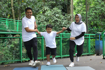 Asian family having fun exercising sport together at the park. 
