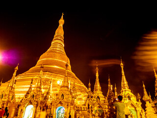 The golden pagodas and mondops are illuminated in the light of the night - 516557026