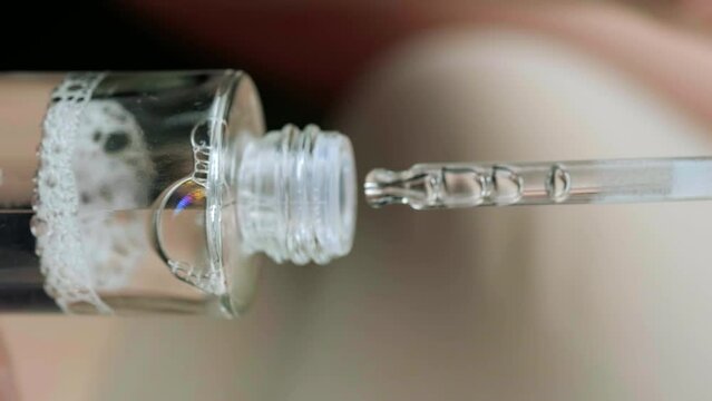 Glass bottle with micellar water in women's hands. Skin care and healthy care. Close-up.