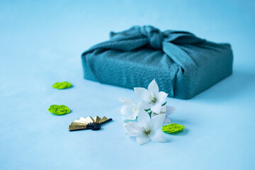 風呂敷包みと白いキキョウの花と水引と金色の扇