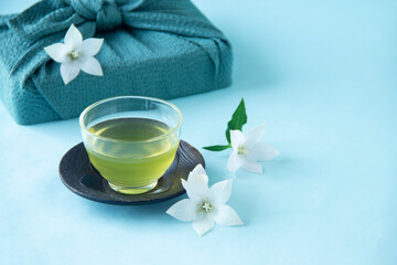 Obraz na płótnie Canvas 風呂敷包みと白いキキョウの花と冷たい緑茶