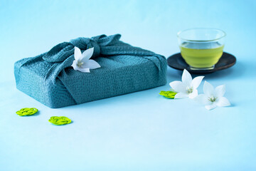 風呂敷包みと白いキキョウの花と冷たい緑茶