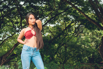 A sultry and alluring young woman with flawless light brown skin wearing a red halter top and light...