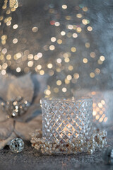 Christmas blurred candle in a faceted glass vase, ball. Blurred light beautiful background with...