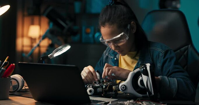 A busy girl sits at her desk in a dark room lit by an office lamp, a teenager builds a robot from scratch, connects wires to create an electronic system that powers the toy.