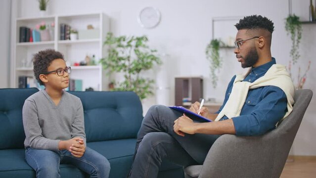 African American psychologist talking with a boy, mental health assessment