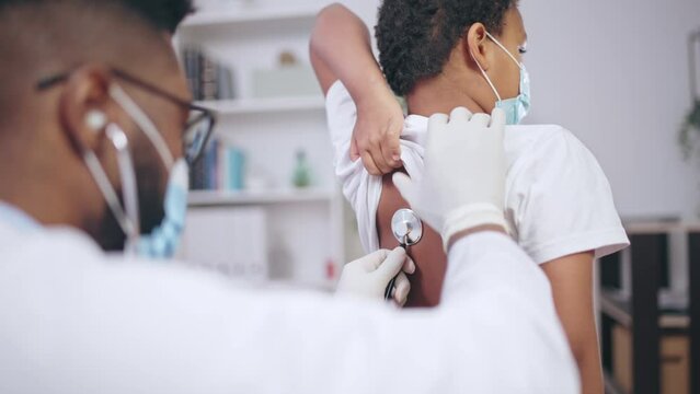 African American doctor examining little patient, listening to child's lungs