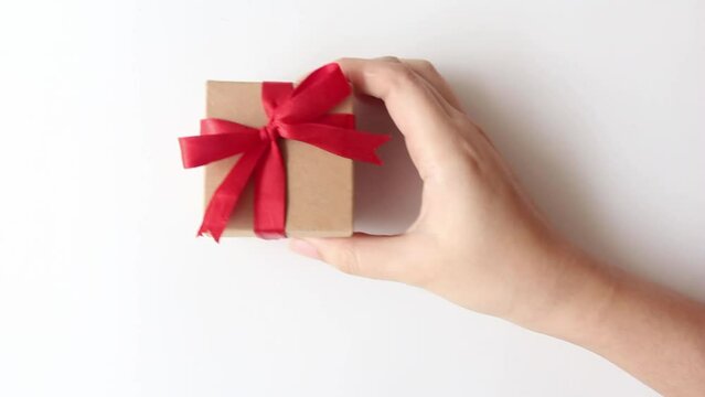 woman hands holding a small gift box on white background. 