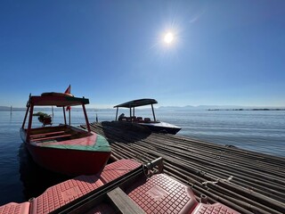 Beautiful Calm Water Reflection Lake and Fisherman working fishing on Boats with Blue Sky and Sunny Weather Clear Horizon