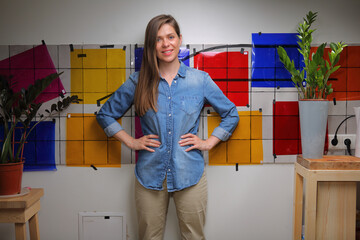 Woman designer standing against wall with color palette