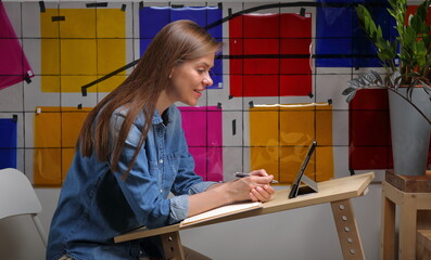Woman student designer or teacher working or learning. Wall background with color palette