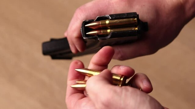 Male hands loading Kalashnikov assault rifle magazine with cartridges. Load magazine with bullets 7.62 caliber for ak 47 closeup