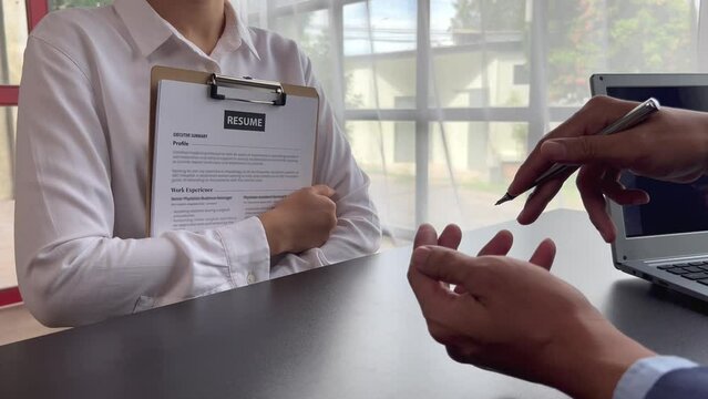 The manager is interviewing job applicants and reading the candidate's personal information on the resume. The idea of recruiting to recruit people to work in the missing position.
