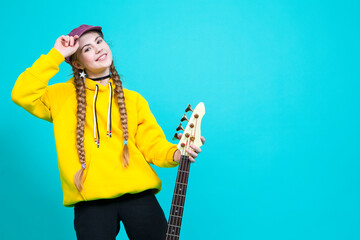 Portrait of Winsome Caucasian Female Guitar Player With White Bass Guitar Holding Instrument Nearby...