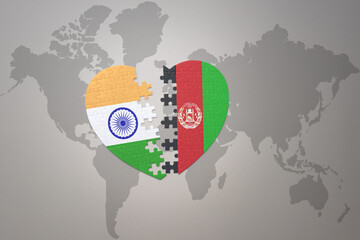 puzzle heart with the national flag of india and afghanistan on a world map background.Concept.