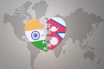 puzzle heart with the national flag of india and nepal on a world map background.Concept.