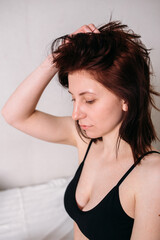 Naklejka premium Portrait of a young beautiful brunette lying in bed wearing underwear