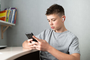 teenage boy using smartphone for study or communication, looking at mobile screen