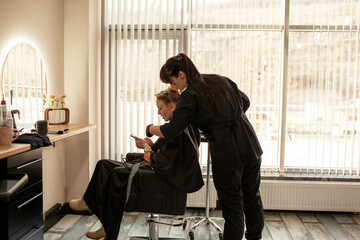 
Close-up of female hands holding the hair rows in professional hairstyles salon. The hairdresser...