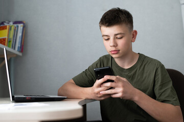 teenage boy using smartphone for study or communication, looking at mobile screen