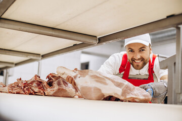 Man butcher at the freezer with meat