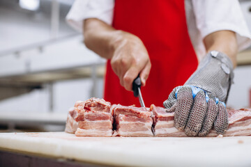 Man butcher at the freezer cutting meat