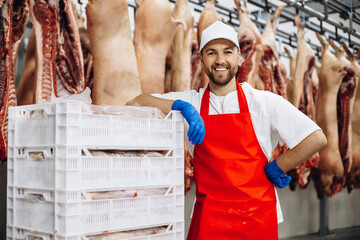 Buthcer at the freezer with box full of meat