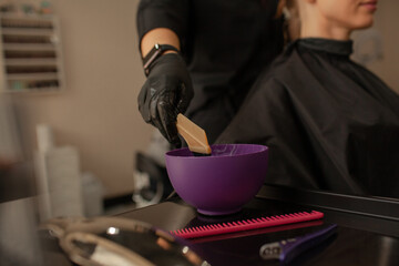 
Close-up of female hands holding the hair rows in professional hairstyles salon. The hairdresser...