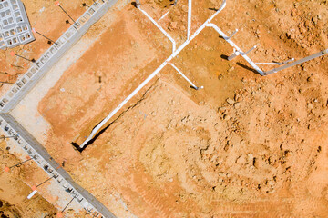 Installing sewer and water pipes in the ground under the foundation of a new residential construction home an aerial view - obrazy, fototapety, plakaty